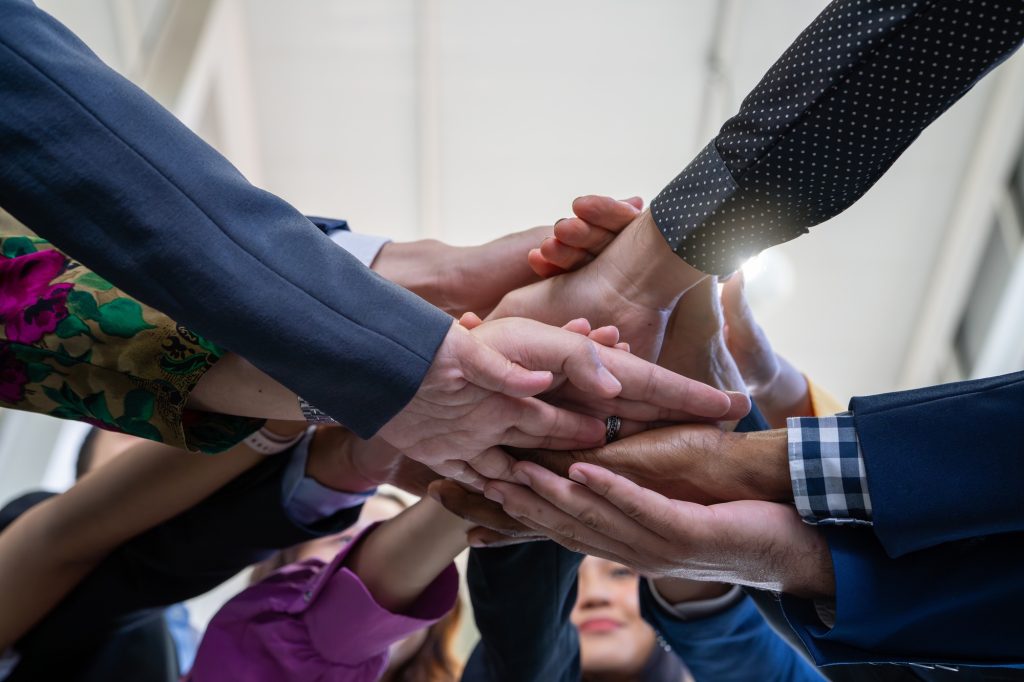 Team, teamwork, and unity concept. Diverse team putting hands together. Group of diverse business